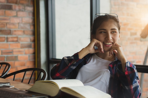 美しいアジアの女性、学生は楽しいと幸せで本を読んで、自由な時間に幸せ。