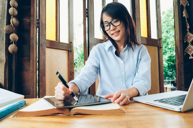 Beautiful asian business woman working with laptop, phone, and tablet