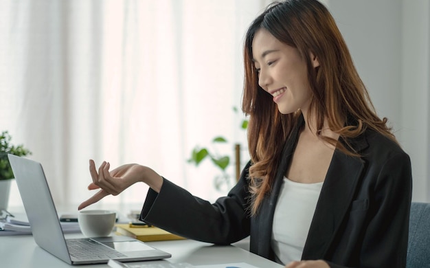 아름다운 아시아 여성 사업가는 officexA에서 노트북 계산기를 사용하여 차트를 분석합니다.