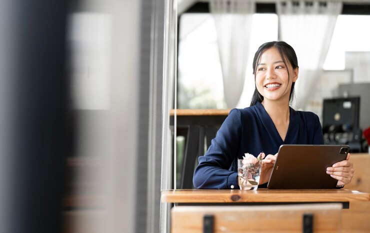 Photo beautiful asian businesswoman in the cafe using digital tablet and smiling looking up