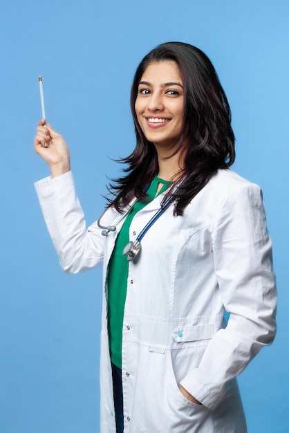 Beautiful Asian Doctor Lady pointing with pointer on copy space, studio shot. Isolated on a gray background. Medical student general practitioner
