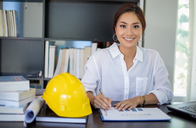 Beautiful Asian engineering women checking document and using notebook working at home