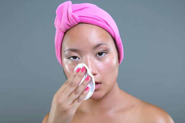 Beautiful asian ethnicity woman cleaning her face