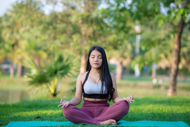 Beautiful asian fat woman play yoga at the parkNeed to slim fit body