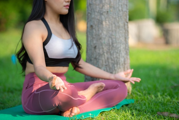 Beautiful asian fat woman play yoga at the parkNeed to slim fit body