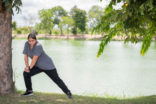 Beautiful asian fat woman play yoga at the parkNeed to slim fit body