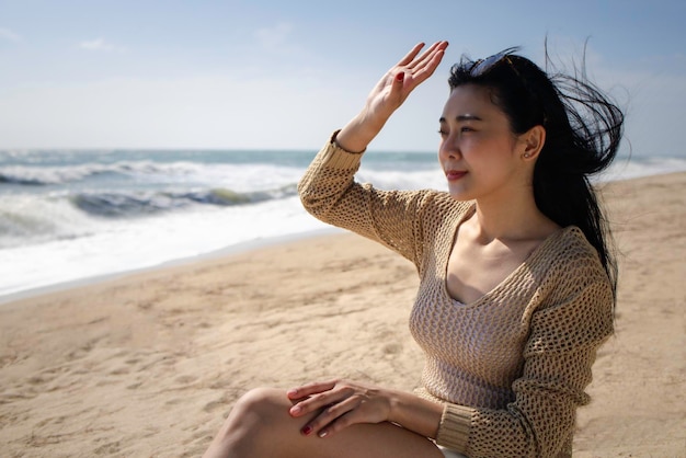 아름다운 아시아 여성이 해변에서 휴식을 취합니다.