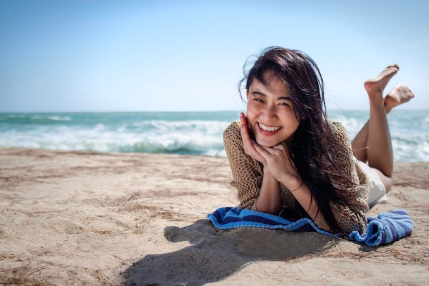 아름다운 아시아 여성이 해변에서 휴식을 취합니다.