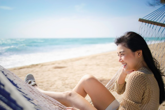 사진 아름다운 아시아 여성이 해변에서 휴식을 취합니다.