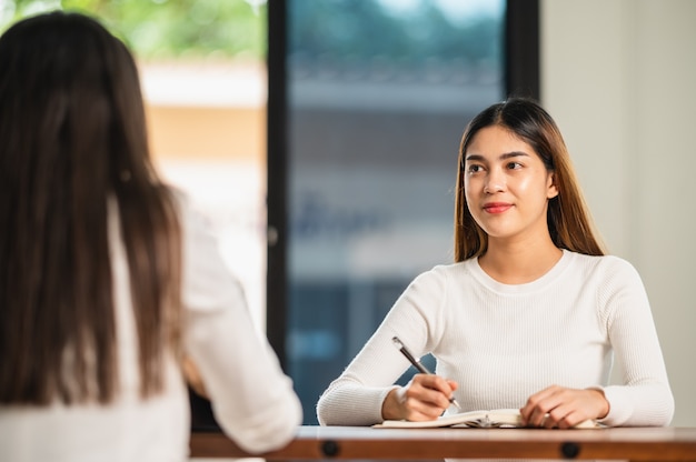 美しいアジアの女子学生が列教育ライフスタイル大学に座っている大学の教室の学生で試験のために座る