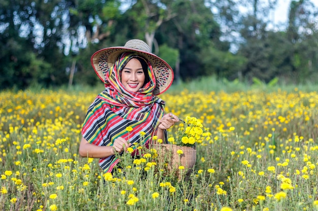 Foto bella ragazza asiatica del giardiniere nel giacimento di fiori del tagete