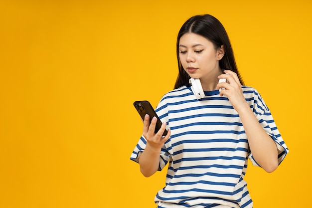 Beautiful asian girl in headphones with phone