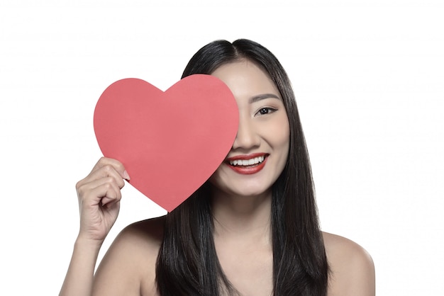 Photo beautiful asian girl holding red heart