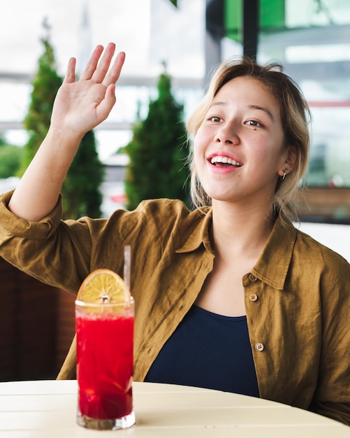 Photo beautiful asian girl waving hand to friends