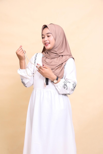 beautiful Asian Muslim adult girl in hijab holding prayer beads expression elegant smile candid fasc