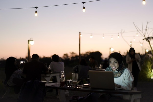 Beautiful asian muslim lady casual wear working using laptop at night