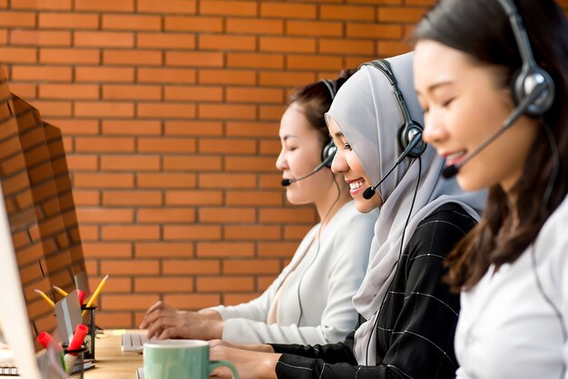 Photo beautiful asian muslim woman working in call center with her team