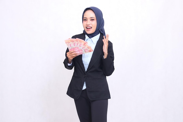 A beautiful Asian office woman wearing a hijab stood surprised and happy to get and take away rupiah