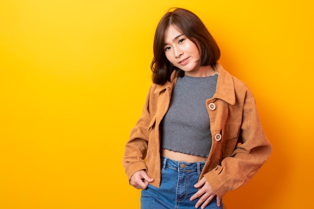 Beautiful asian student on yellow wall