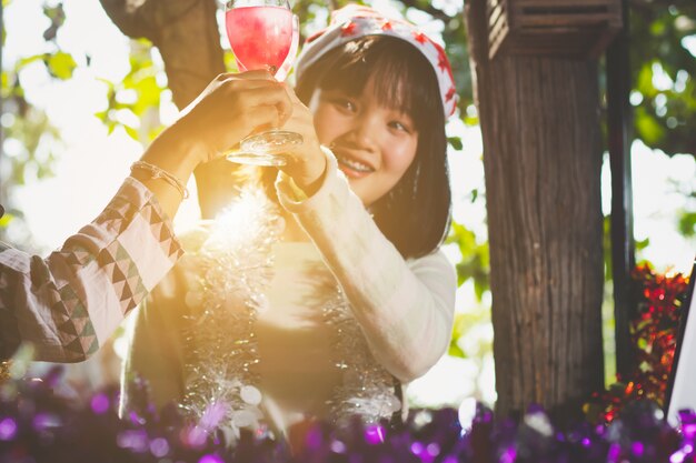 Photo beautiful asian teen girls clinking glasses with friends in new year holiday party.