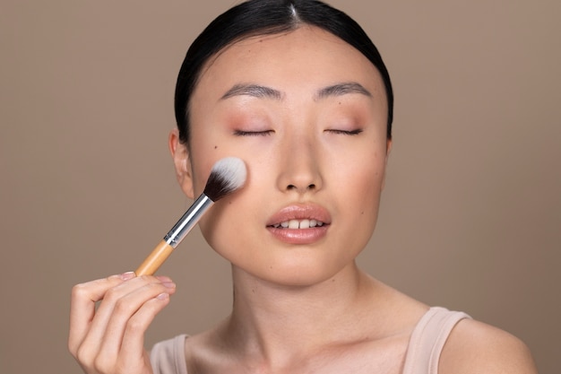 Foto bella donna asiatica che applica trucco