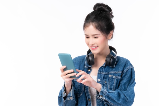 白い背景の携帯電話で隔離のスマートフォンを再生する美しいアジアの女性かわいい女の子は、有料のオンラインショッピングにオンラインバンキングを使用しています