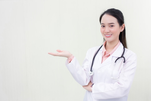 Photo beautiful asian woman doctor shows her hand to present something on white background.