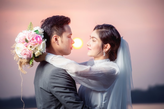 Beautiful asian woman dressed as a bride on white background