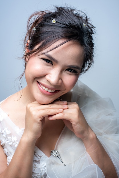 Beautiful asian woman dressed as a bride on white background