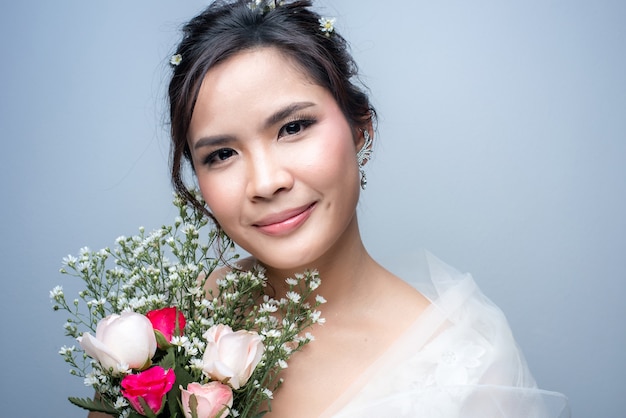 Beautiful asian woman dressed as a bride on white background