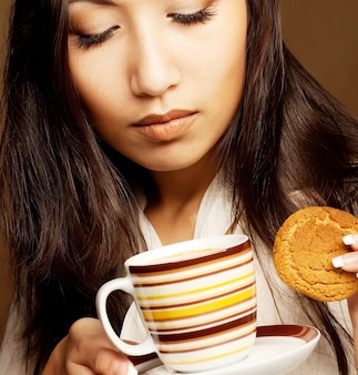 Bella donna asiatica che beve caffè o tè