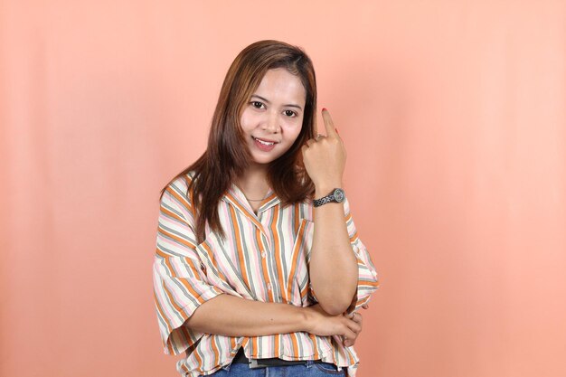 Beautiful asian woman feeling happy and relaxed isolated with peach background