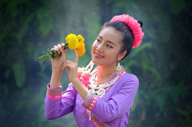 美しいアジアの女性の花を手に