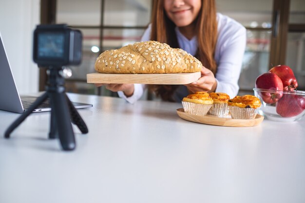 카메라에 비디오를 녹화하는 아름다운 아시아 여성 음식 블로거 또는 블로거