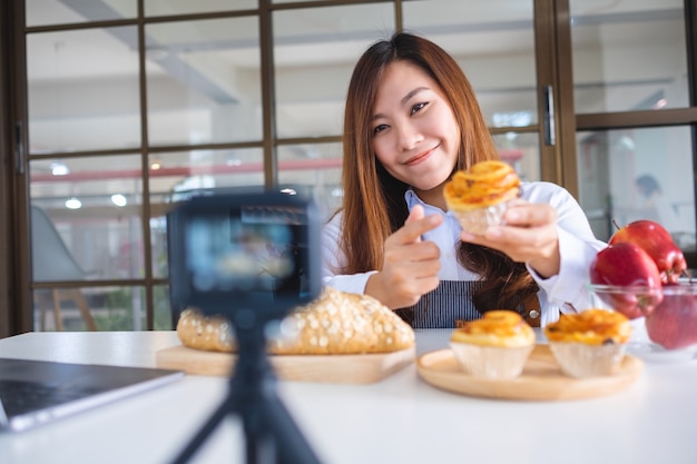 카메라에 비디오를 녹화하는 아름다운 아시아 여성 음식 블로거 또는 블로거