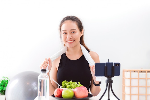 사진 아름 다운 아시아 여자 건강 블로거 사과 fruite와 깨끗 한 다이어트 음식을 보이고있다.