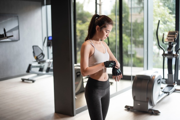 Photo beautiful asian woman is doing exercise in the gym