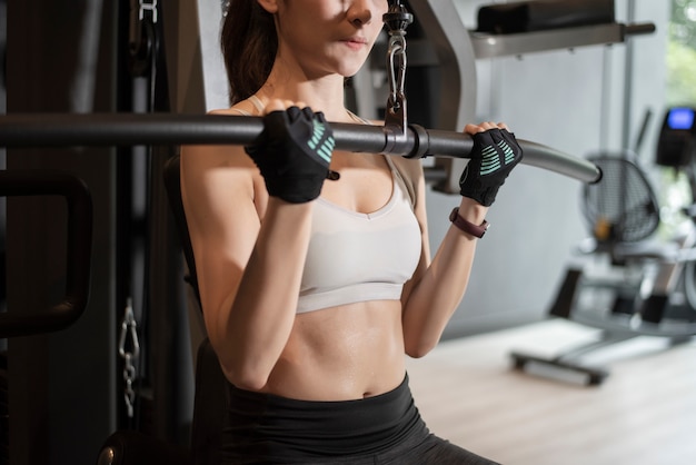 La bella donna asiatica sta facendo l'esercizio in palestra