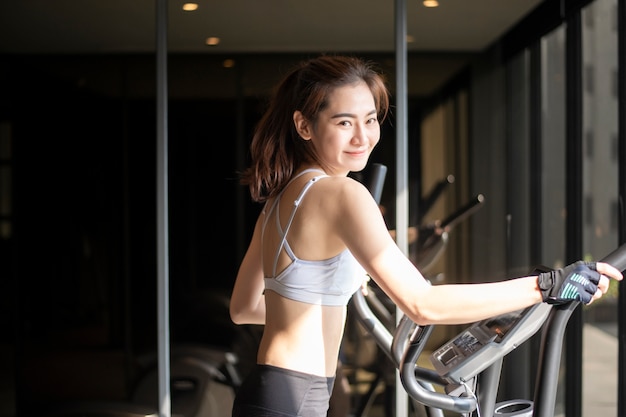 아름 다운 아시아 여자는 체육관에서 운동을하고있다