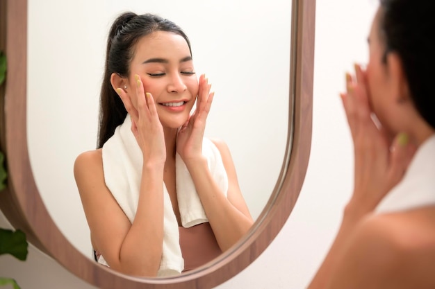 Beautiful asian woman is washing and cleaning her face