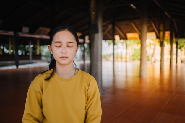 Beautiful asian woman keep calm and meditates at temple for\
healthy trend lifestyle