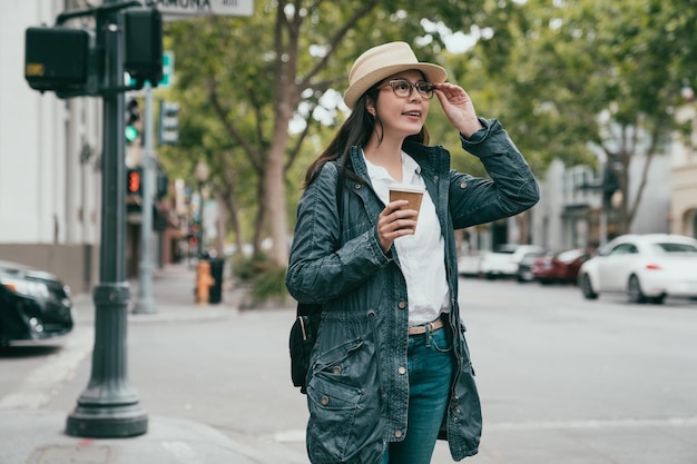 beautiful asian woman looking happily forward and standing in the street with a smile.