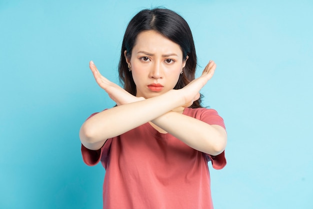 Bella donna asiatica che fa una x a mano con una faccia arrabbiata