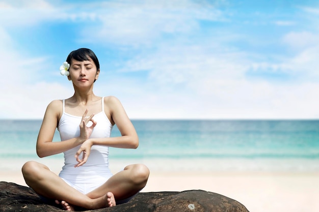 Beautiful Asian Woman Meditating at Beach