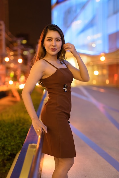Beautiful Asian woman outdoors in Bangkok, Thailand at night