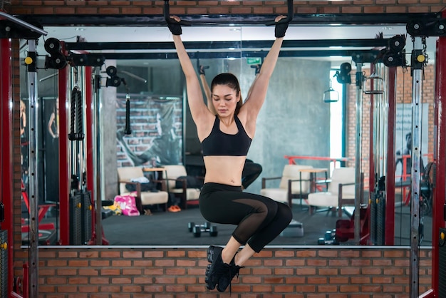 La bella donna asiatica gioca a fitness in palestra la ragazza della thailandia ha un corpo snello tempo per l'esercizio la gente ama la brughiera allunga il corpo prima dell'allenamento donna sportiva riscalda il corpo solleva la barra d'acciaio