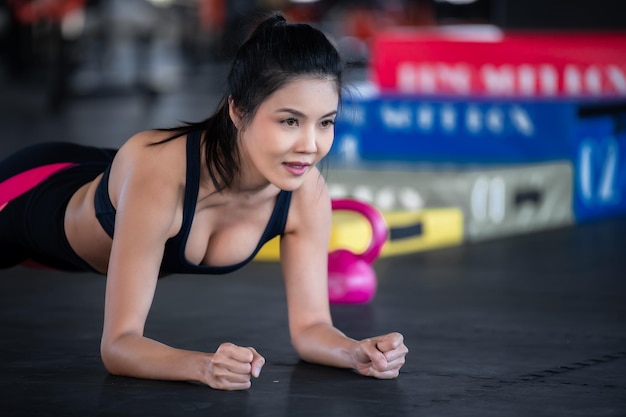 Beautiful asian woman play fitness in the gymthailand girl has\
a slim bodytime for exercisepeople love heathstretching body before\
workoutsport woman warm up bodypush up with dumbell