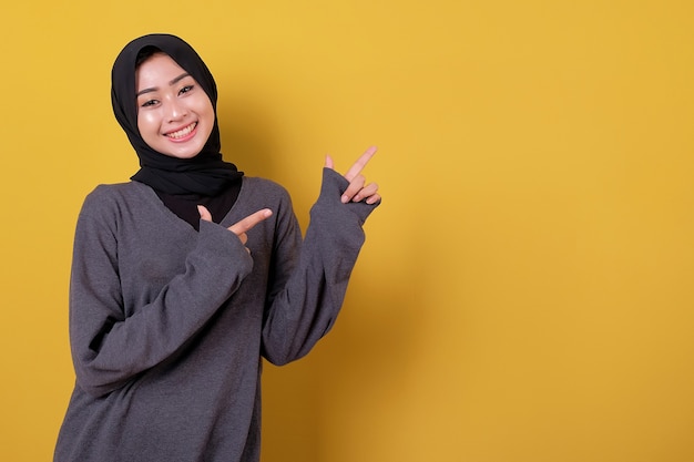 Beautiful asian woman pointing something using casual T shirt