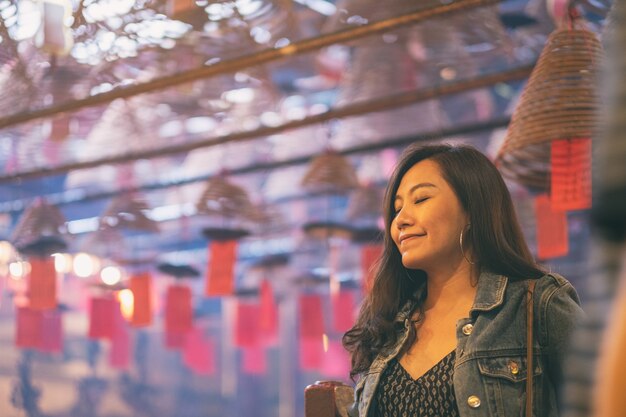 Foto una bella donna asiatica che prega nel tempio cinese