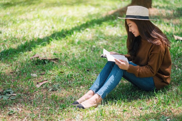 A beautiful Asian woman reading a book while sitting in the park